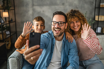 self portrait or video call of family of 3 smile and wave