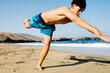 © Adrian Rodd/Stocksy - Skilled teenage spends summer vacation doing acrobatics on the sand
