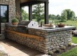 © Professional Agency - Beautiful outdoor kitchen with stone walls and built-in grill