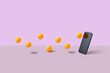 © Yaroslav Danylchenko/Stocksy - Orange balls bouncing off surface towards mobile phone screen