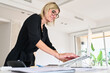 © Guille Faingold/Stocksy - Pro woman using tablet in modern office