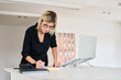 © Guille Faingold/Stocksy - Woman highlighting notes at a modern office desk