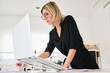 © Guille Faingold/Stocksy - Professional at desk looking at paperwork