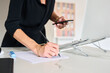 © Guille Faingold/Stocksy - A person writing notes while using a smartphone