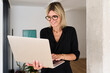 © Guille Faingold/Stocksy - Woman using laptop in home office