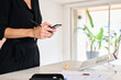 © Guille Faingold/Stocksy - Businesswoman on smartphone at desk
