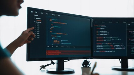 Slow motion back end software developer engineer for computer programming working together on debugging writing computing code, solving complex algorithms display on monitor in office. Burgeoning
