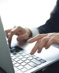 Wall Mural - close up of business woman hands typing on laptop computer and digital tablet, searching and surfing