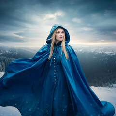 Gorgeous fantasy Woman Snow Queen blue raincoat cape hood flutters waving fly wind, sunrise sunset winter frozen valley covered snow blue white dramatic sky clouds heaven princess