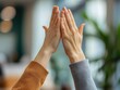 © praewpailyn - Two hands meeting in a gesture of connection, symbolizing unity and collaboration in a bright and modern environment.