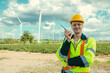 © Quality Stock Arts - Smart Caucasian Engineer technician male worker standing at Wind Turbines working service manager at wind electricity generator farm field.