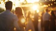 © stockagency - A blurred silhouette of a couple enjoying a sunset gathering, with a group of friends in the background.