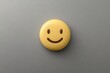 © Atlas Studio - A Cheerful Yellow Smiling Face Against a Gray Background, Symbolizing Joy and Positivity in a Minimalist Design