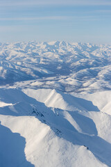 Wall Mural - aerial view of snow-capped mountains. winter snowy mountain landscape. air travel to the far north o