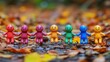 © ACE STEEL D - Colorful Figurines Holding Hands in Autumn Leaves
