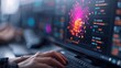 © DuangphonKPR - A user interacts with a computer displaying vibrant data visualizations, suggesting a focus on data analysis or programming.