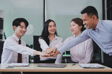 Group of business workers standing with hands together at the office