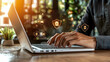 © Anucha - A person types on a laptop surrounded by icons representing online security and privacy, highlighting the importance of cybersecurity in today's digital age.