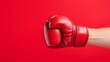 © Postmodern Studio - A powerful red boxing glove is punching forcefully against a vivid red background