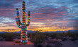 © K KStock - Cactus in the desert at sunset decorated with colorful Christmas lights.  Room for text