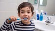 © Жанна Грабчак - A young boy holding a toothbrush in his mouth, preparing for brushing teeth