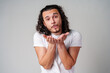© fotofabrika - A man with curly hair blows a kiss to the camera while wearing a white t-shirt