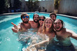 © tynza - Group of friends taking a selfie in the pool, cheerful expressions, bright summer day.
