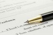 © Rosnani - A pen resting on a document for signing.
