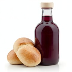 A glass bottle of red wine vinegar and two baked rolls on a white background.