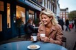 © Iigo - Beautiful young woman drinking coffee in a street cafe in London.