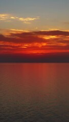 Wall Mural - flying up over a calm sea surface during a beautiful sunset, 4k