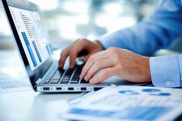 Leinwandbilder - A Man's Hands Typing on a Laptop with Financial Data on Screen