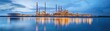 © Emma - Oil refinery reflecting on water, serene industrial setting, balanced composition