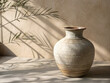 © Konstantin - Ceramic vase with natural shadows on a neutral backdrop, minimalist home decor concept