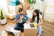 © AntonioDiaz - Young couple in their new apartment, sitting amidst cardboard boxes and budgeting for their move
