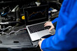 © zphoto83 - A mechanic analyzing vehicle diagnostics using a laptop while working under the hood in an automotive workshop