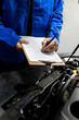 © zphoto83 - Mechanic performing a vehicle inspection and recording findings in a workshop