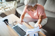 © Marko Geber - Senior woman working on laptop at home