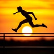 © PuiZera - Silhouette of a runner jumping over a railing at sunset.