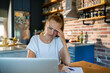 © Geber86 - Woman stressed and frustrated while working on laptop in kitchen