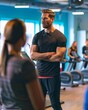 © Philipp - Dynamic fitness coach guiding an energizing workout in a brightly lit, fully equipped gym