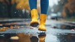 © Sinechana - 25.Woman Wearing Yellow Boots Jumping on Puddle During Rainy Season