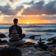 © A4719 - Man meditating on the beach at sunset with rock cairns