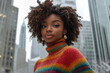 © Aris - Afro woman wearing turtleneck sweater standing among skyscrapers
