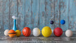 © mahamad - A set of different sports balls and a shuttlecock on a gray wooden table.