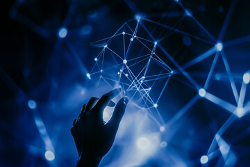 Silhouette of a hand reaching for a glowing blue network..