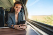 © Barillo_Images - Business travel concept. Businesswoman messaging on smartphone while commuting by train.