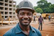 © ThomasLENNE - Close portrait of a smiling 40s Guinea-Bissauan man construction worker looking at the camera, Guinea-Bissauan outdoors construction site blurred background