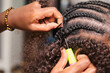 © Cavan Images - Hairdresser making crochet braids hairstyle in afro hair salon