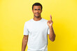 © luismolinero - African American handsome man on isolated yellow background with fingers crossing and wishing the best